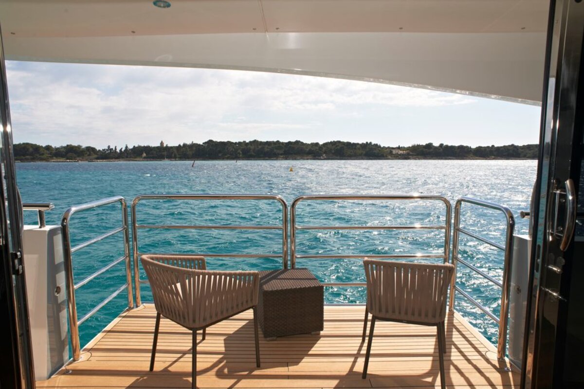 Two chairs and a table on a deck overlooking the ocean