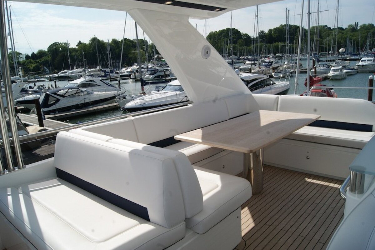 A boat with a table and benches is docked in a marina