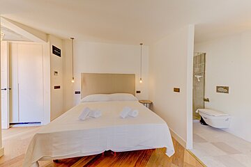 A bedroom with a king size bed and a toilet