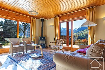 A living room with a couch and chairs and a view of the mountains
