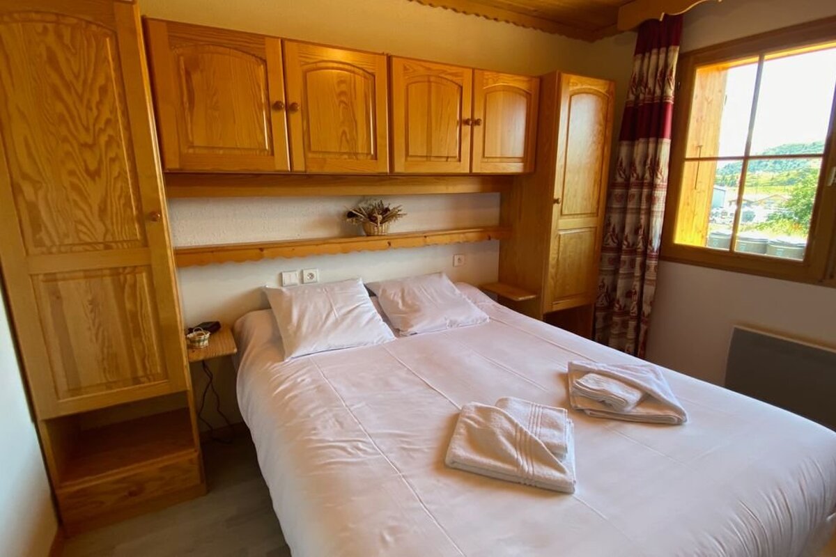 A bedroom with a large bed and wooden cabinets
