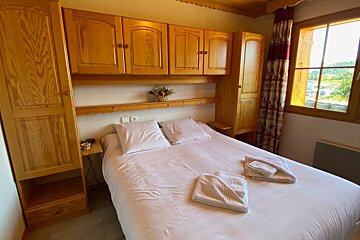 A bedroom with a large bed and wooden cabinets