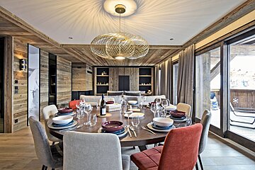 A dining room table with a bottle of wine on it