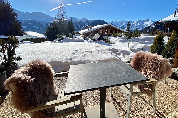 A table with a view of snowy mountains in the background