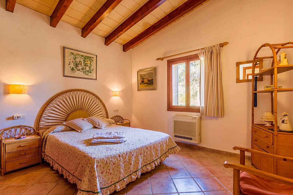 A bedroom with a large bed and a picture on the wall above it