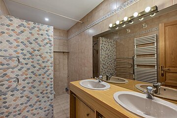 A bathroom with two sinks and a large mirror