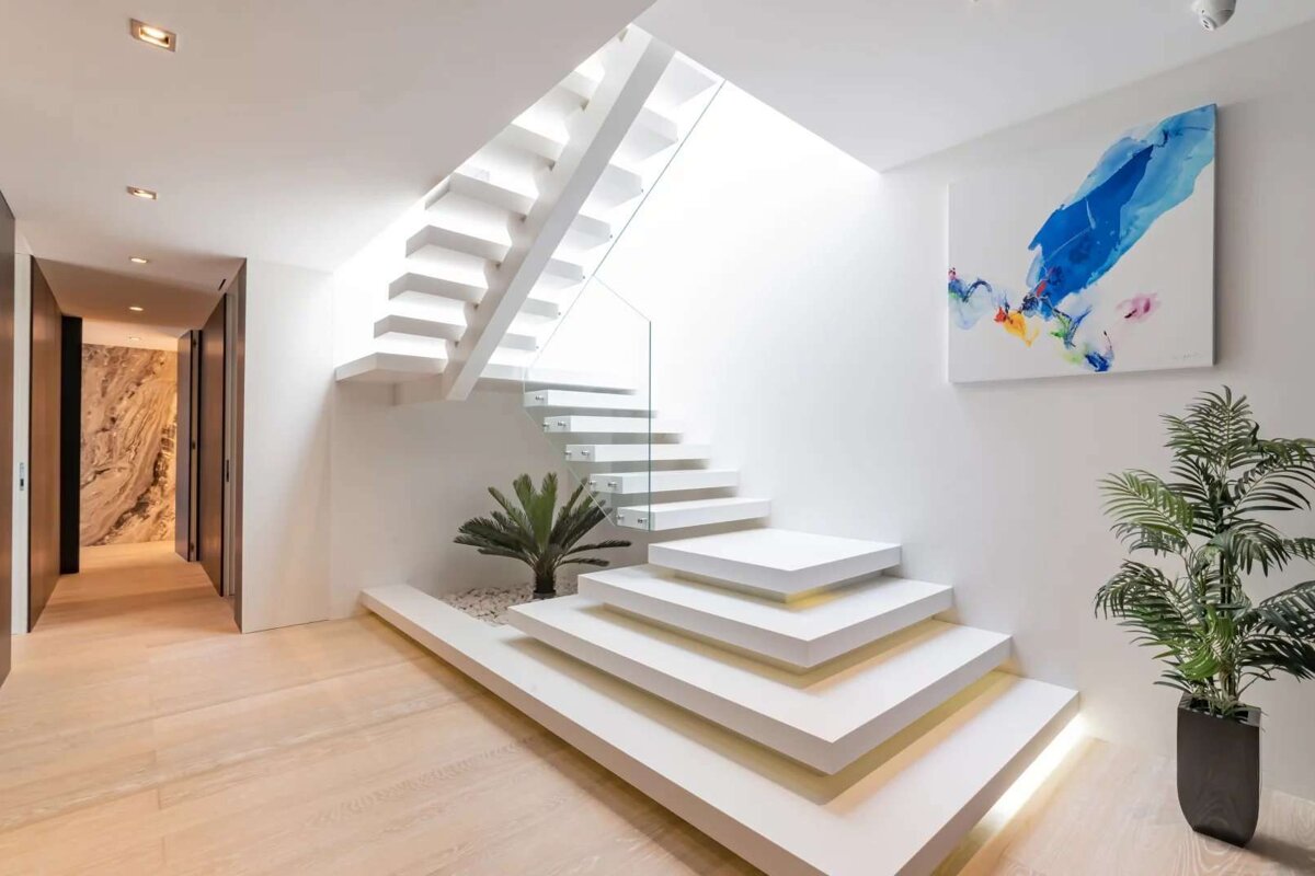 A staircase with a painting on the wall above it