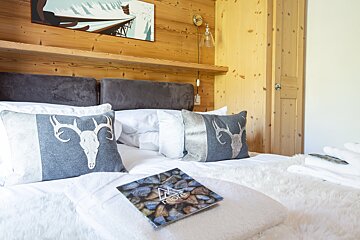 A bed with pillows and a book that says trois on it