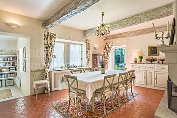A dining room table with a white table cloth and chairs