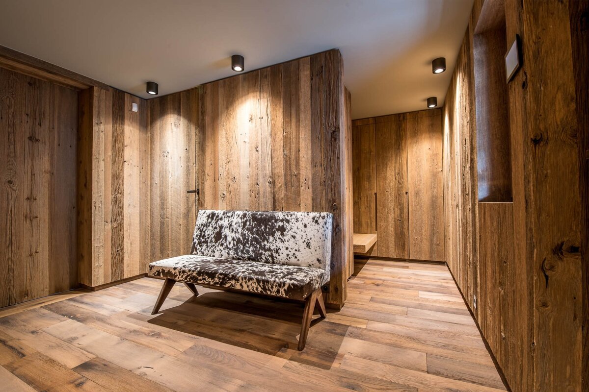 A wooden hallway with a cow print bench in the middle