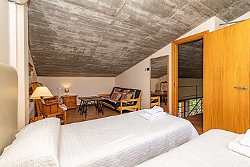 A bedroom with two beds a couch and a mirror