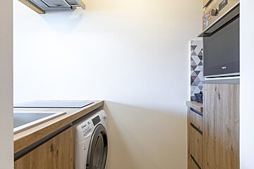 A candy brand washer and dryer in a kitchen