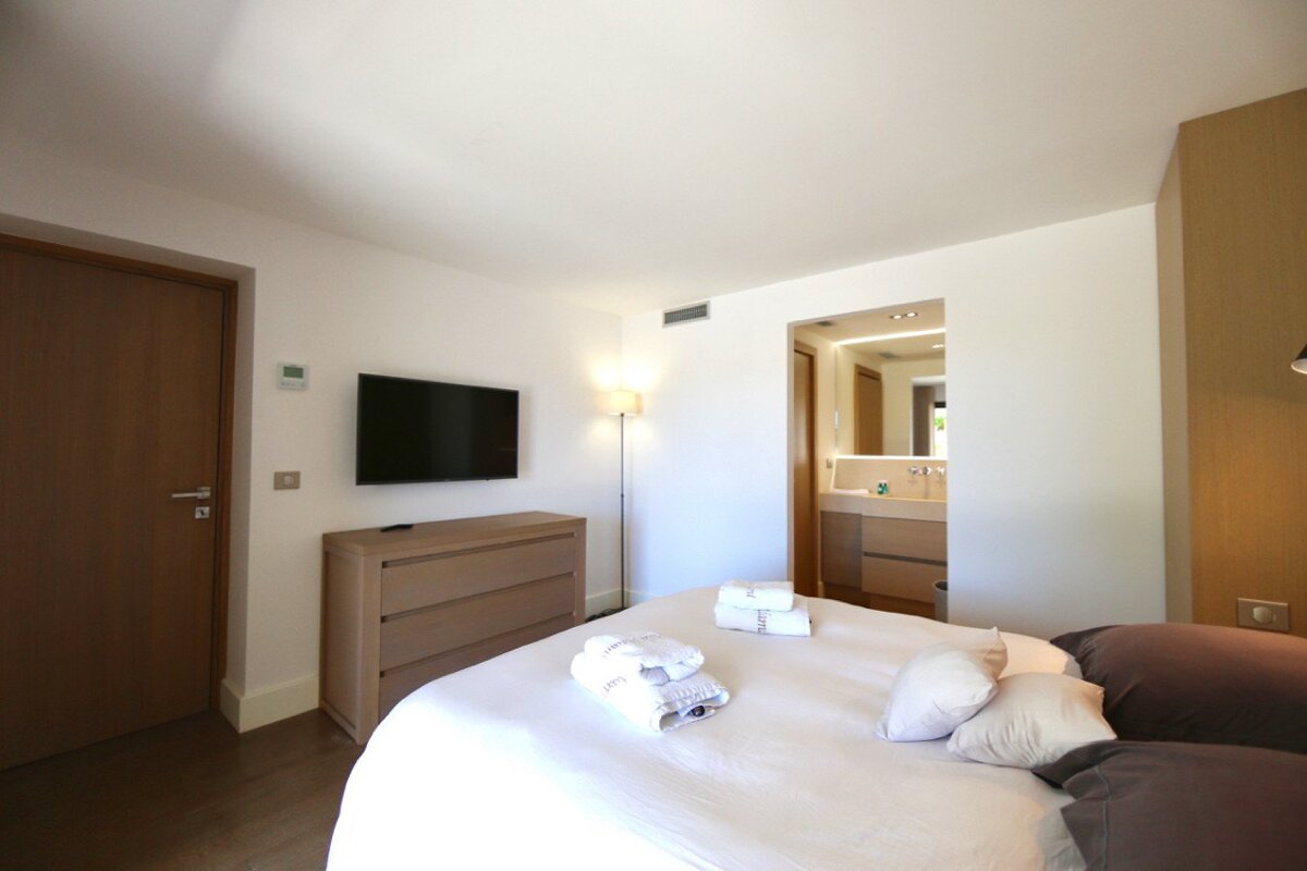 A bedroom with a large bed and a flat screen tv