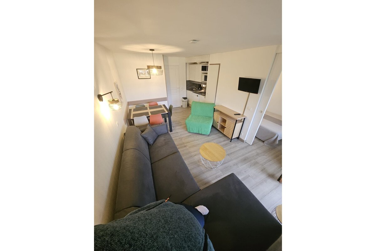 A living room with a table and chairs and a television