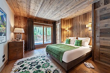 A bedroom with a bed and a poster on the wall that says les alpes