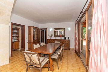 A dining room with a long wooden table and chairs