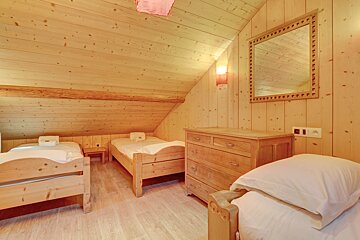 A bedroom with two beds a dresser and a mirror