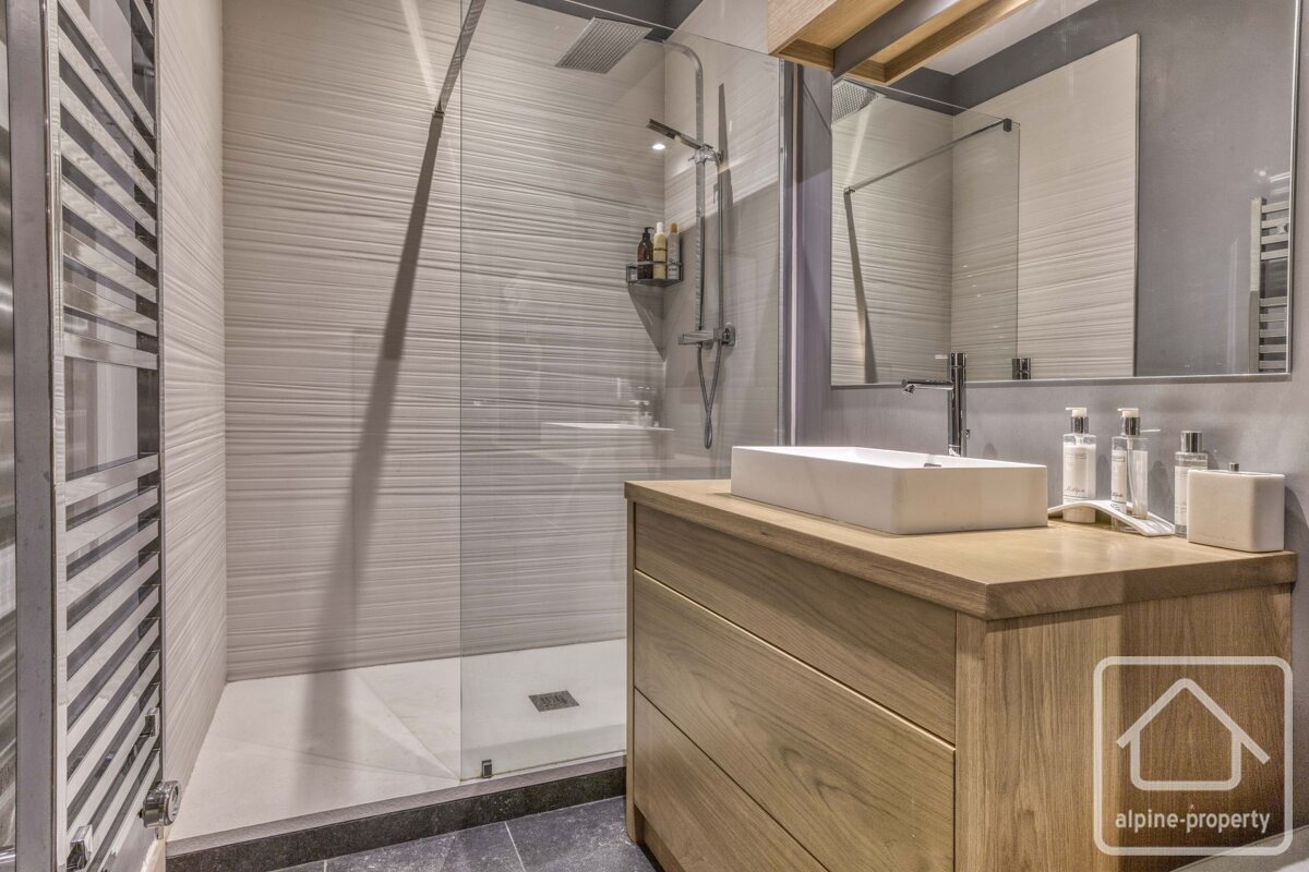 A bathroom with a sink a mirror and a sign that says alpine-property