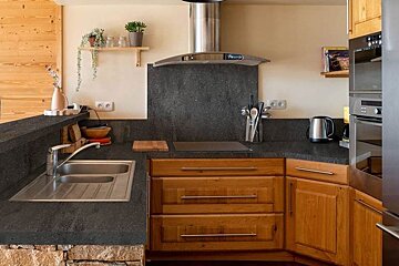 A kitchen with wooden cabinets and a stainless steel refrigerator