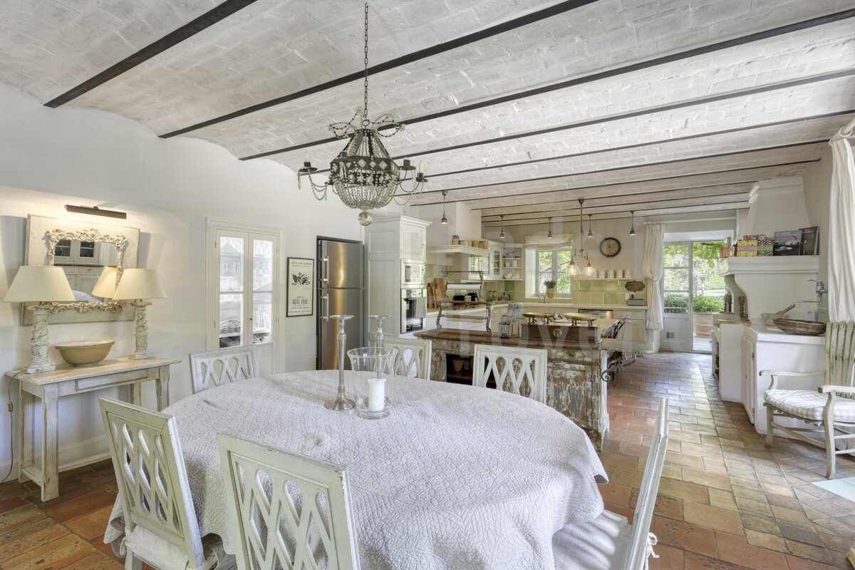A dining room with a table and chairs and a chandelier