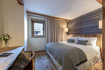 A bedroom with a large bed and a window