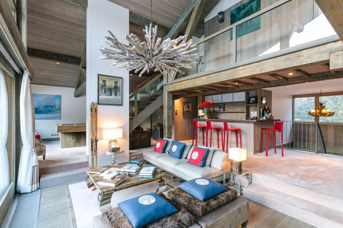 A living room with a couch and a table with blue and red pillows