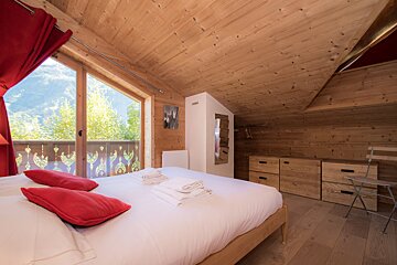 A bedroom with a large bed and a large window