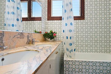 A bathroom with two sinks and a polka dot shower curtain