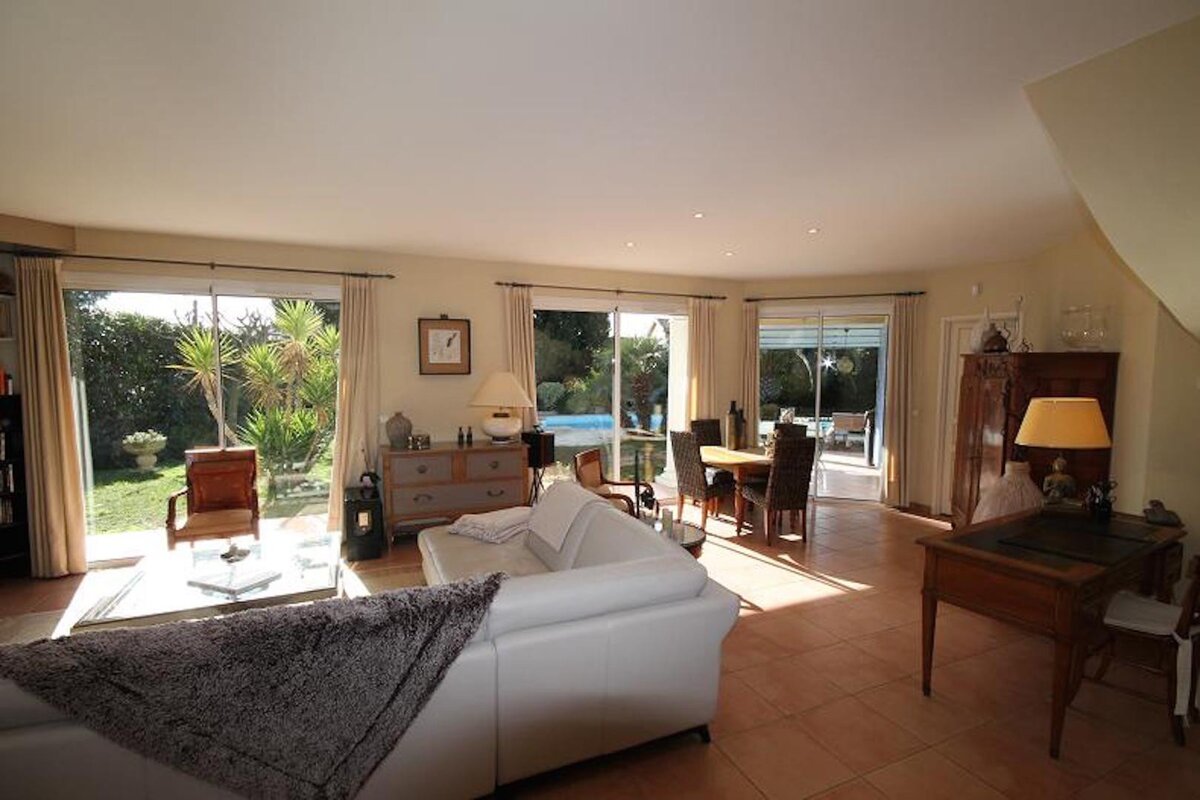 A living room with a white couch and a desk