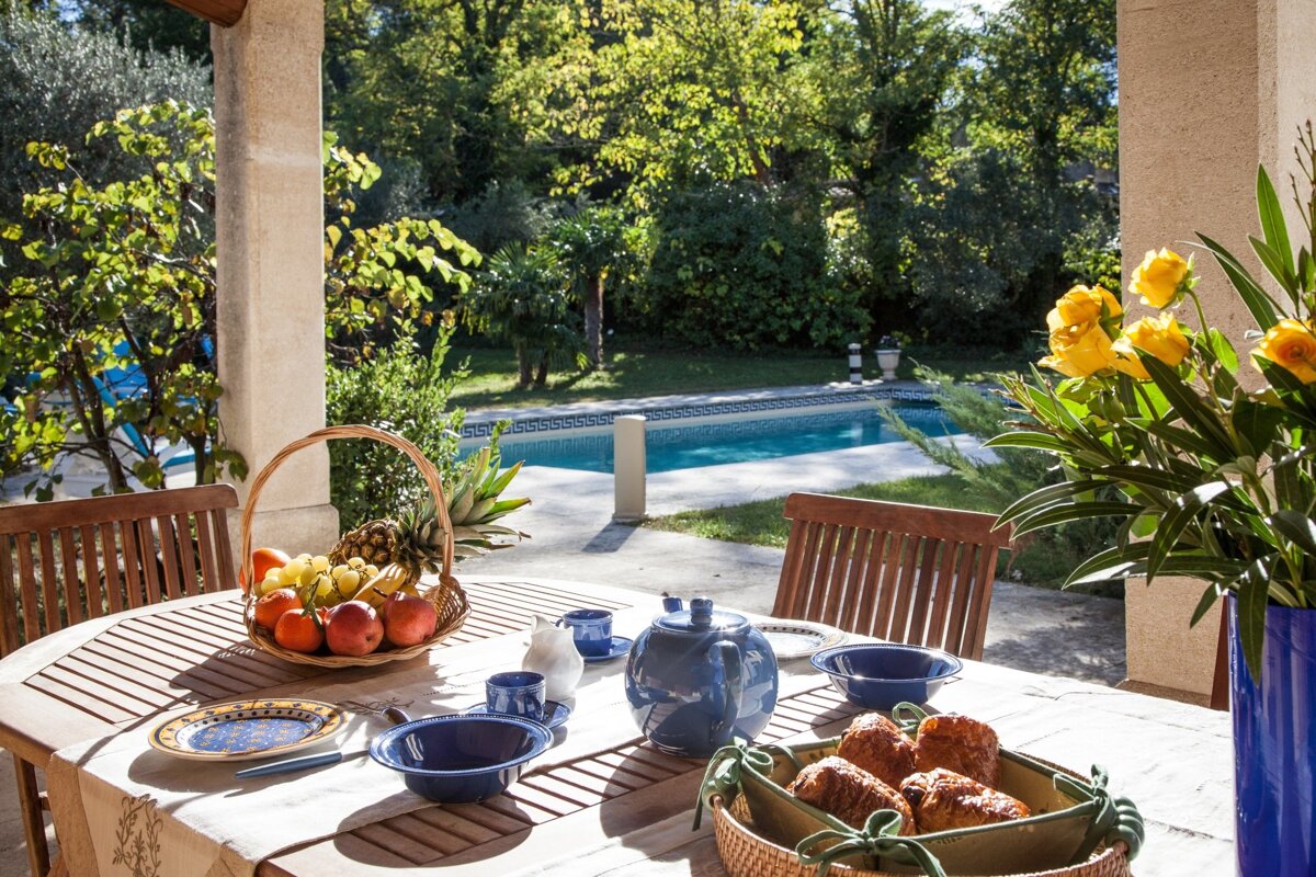 A table with a basket of fruit and croissants on it