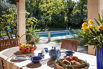 A table with a basket of fruit and croissants on it