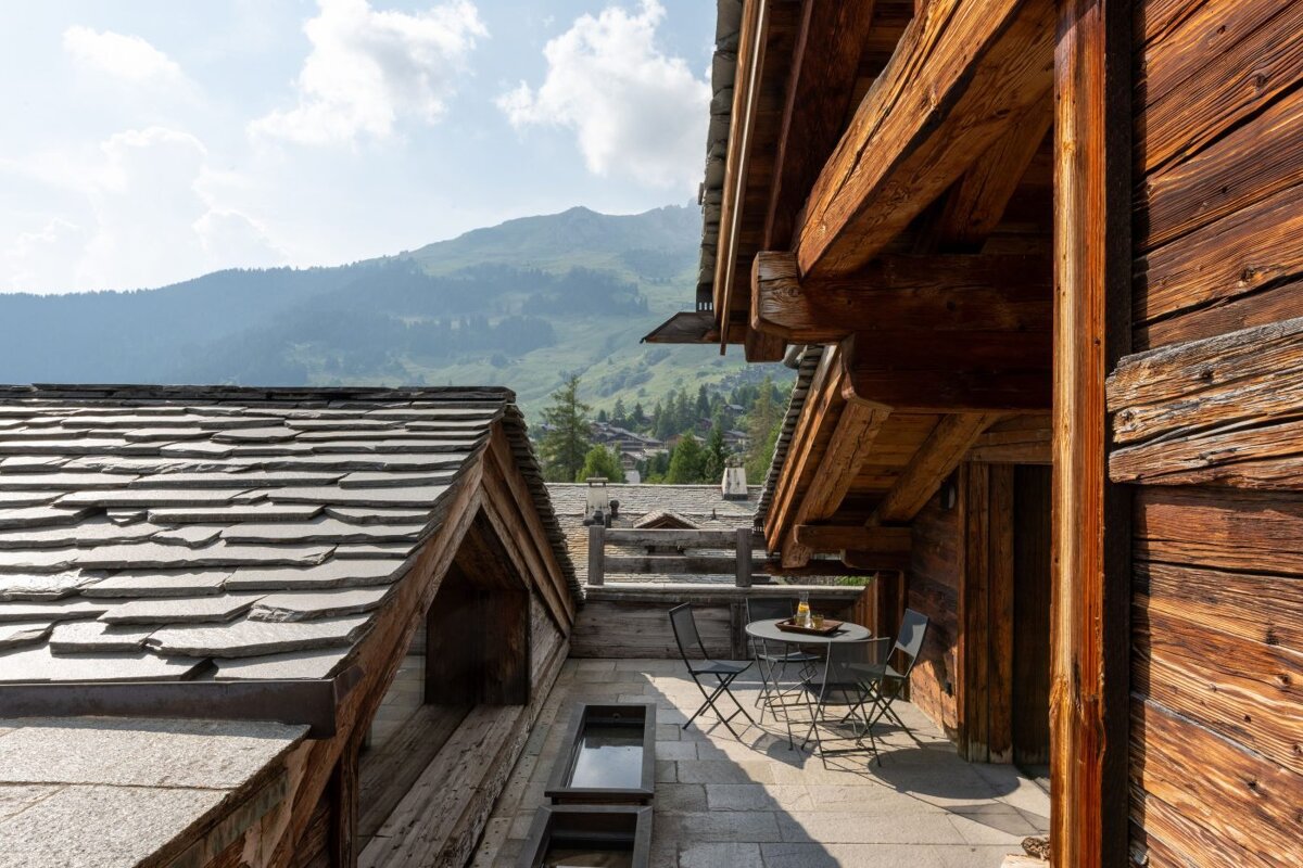 A wooden building with a table and chairs in front of it