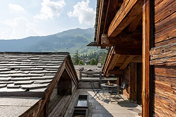 A wooden building with a table and chairs in front of it