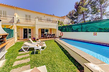 A house with a swimming pool in front of it