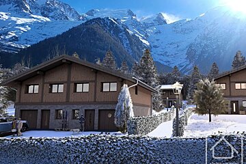 Wooden alpine chalets set in a snowy landscape against a backdrop of majestic, snow-covered mountains.
