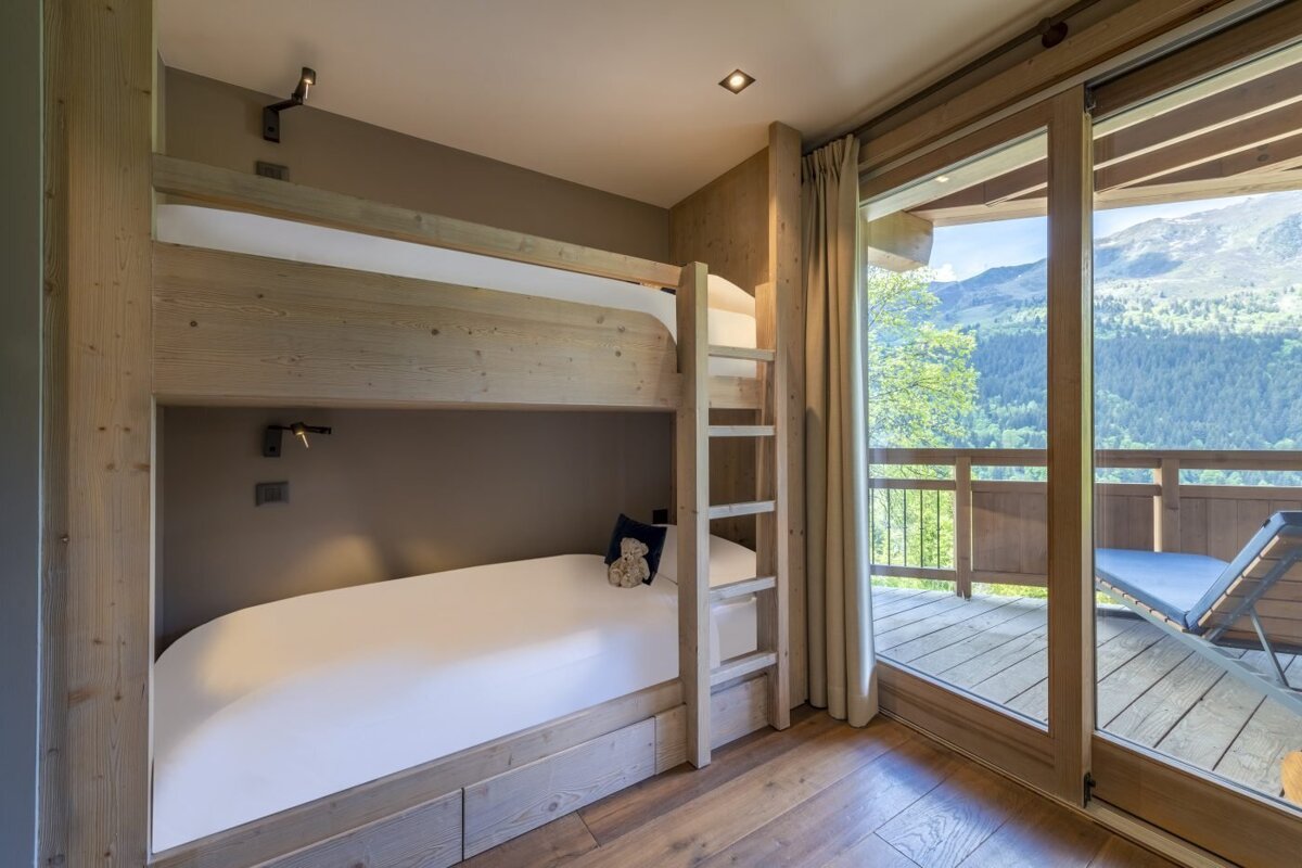 A bunk bed in a room with a view of the mountains