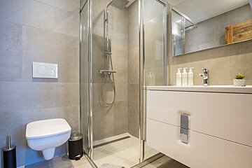 A bathroom with a toilet a sink and a shower