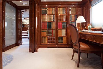 A library with a desk and chair and a lamp