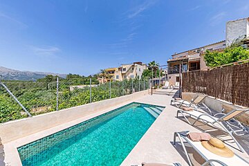 A large swimming pool surrounded by chairs and a fence