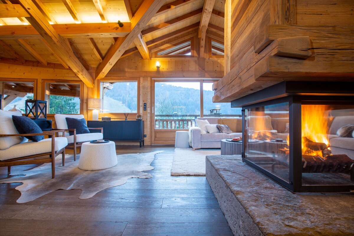 A living room with a fireplace and a view of the mountains