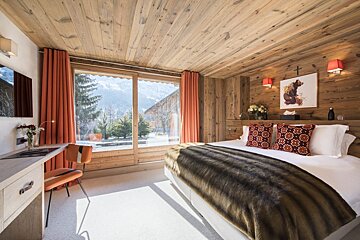 A bedroom with a large bed and a large window