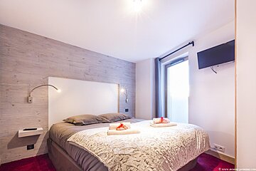 A bedroom with a large bed and a flat screen tv