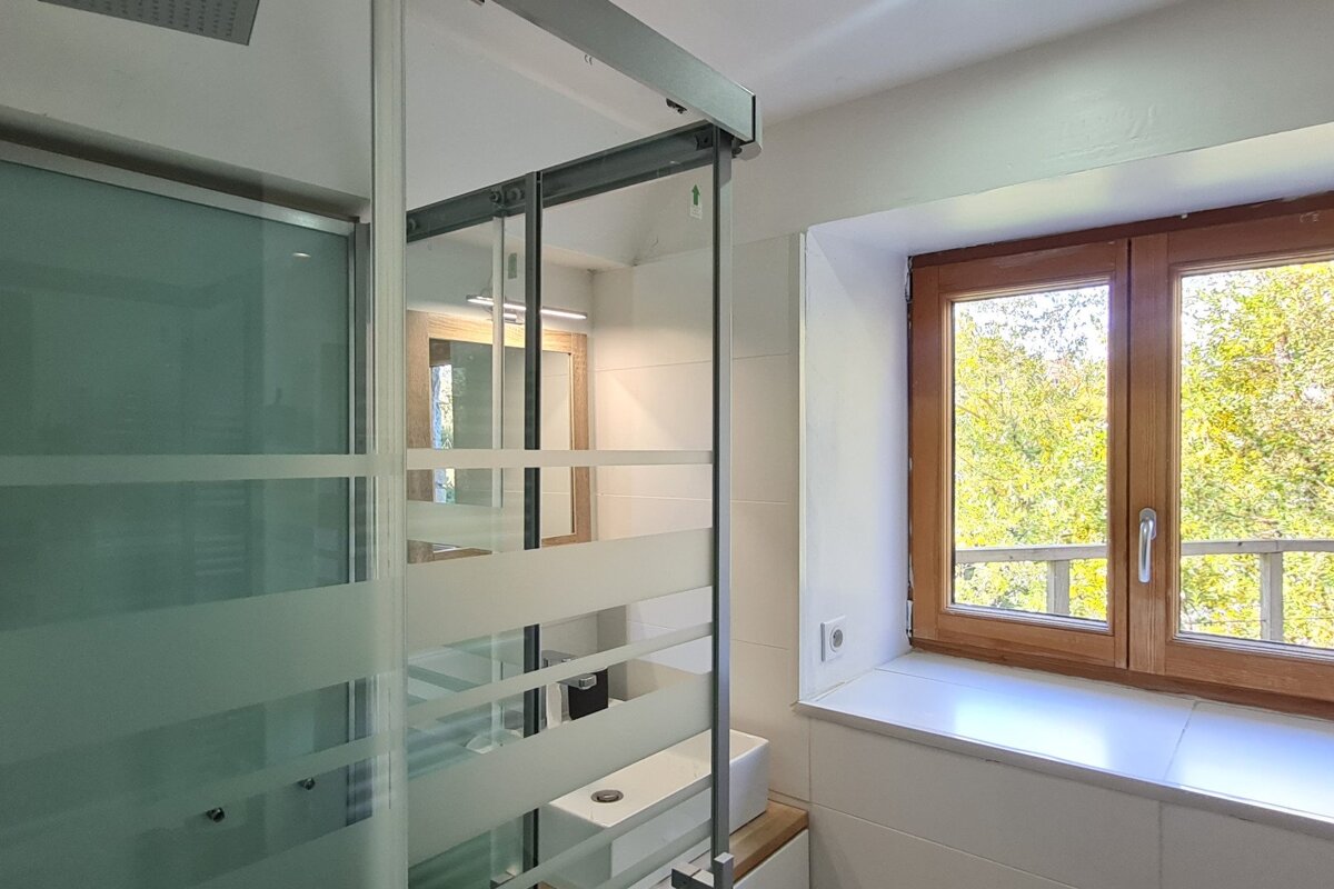 A bathroom with a sliding glass door and a window