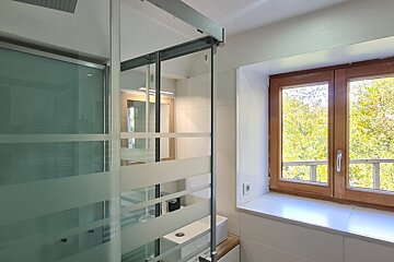 A bathroom with a sliding glass door and a window