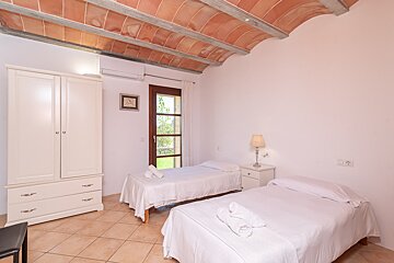 A bedroom with two beds a dresser and a picture on the wall