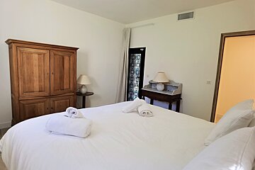 A bedroom with a large bed and two lamps