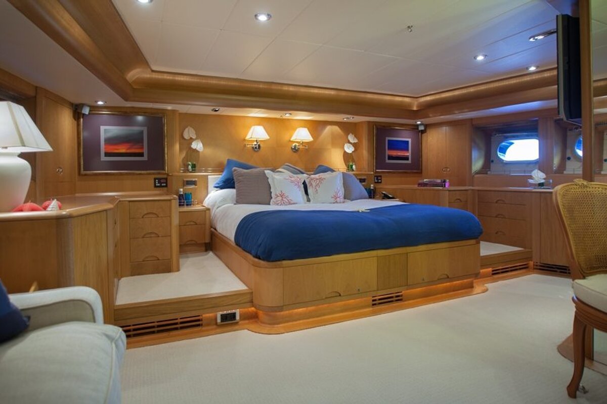 A bedroom with a large bed and a chair
