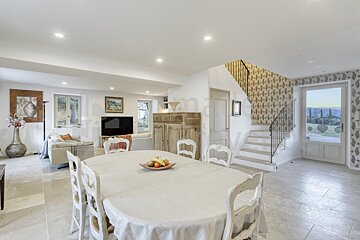 A dining room table with a bowl of fruit on it