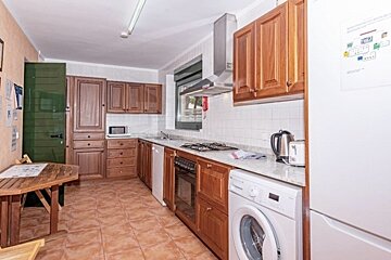 A kitchen with wooden cabinets and a washing machine