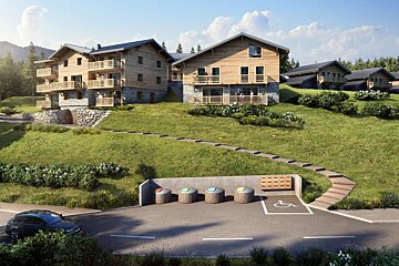Modern wooden alpine chalets on a grassy hillside with a stone path leading up from a road.